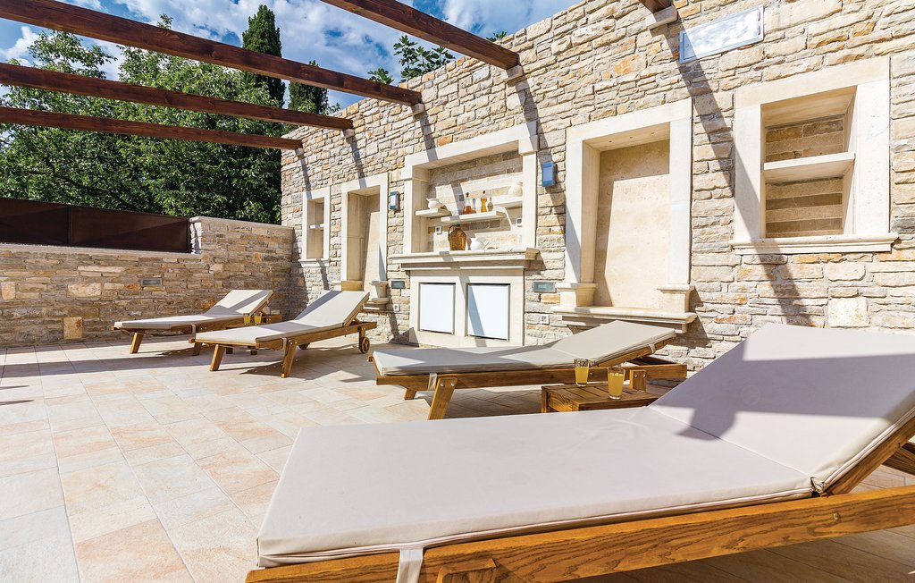 Am Strand am Pool gibt es Holz-Liegestühle, wo Sie genießen können, während die Sonne scheint