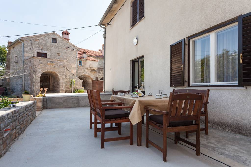 Auf der hinteren Terrasse befindet sich ein Holztisch mit Holzstühlen zum Essen. Neben der Terrasse befindet sich ein Garten mit Gewürzen, die Sie bei