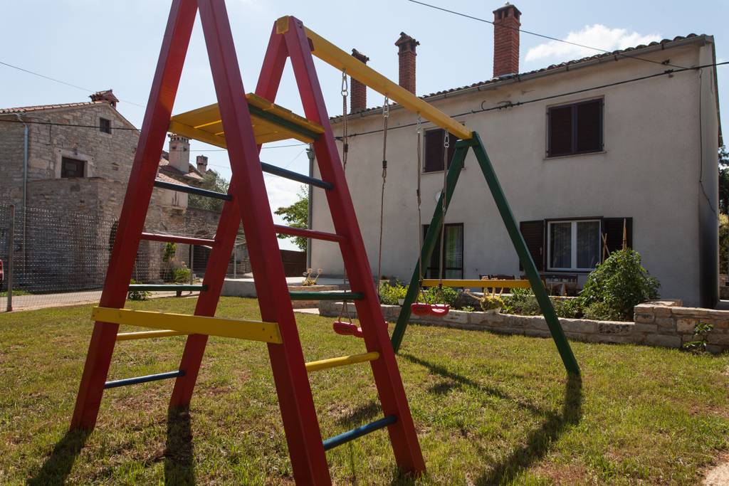 Auf dem Rasen neben der Terrasse befindet sich eine Schaukel für Kinder