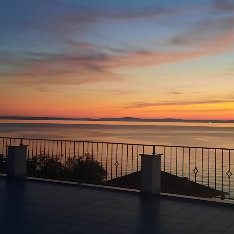 Ihre Terrasse mit Meerblick, ausgestattet mit Grill, Tisch, Stühlen, Sonnenschirm.