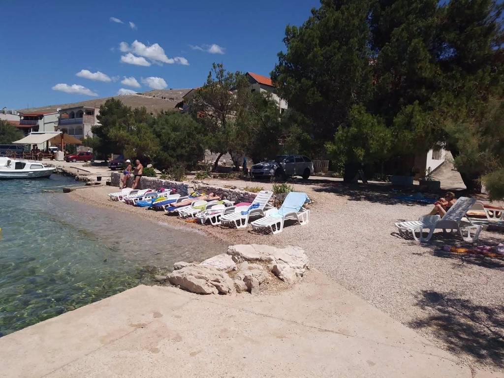 Strand vor dem Haus mit Sonnenliegen und Naturschattierungen