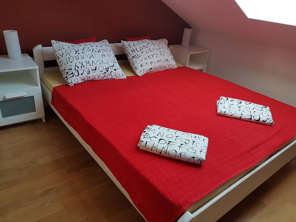 Rote Schlafzimmer befindet sich ein Doppelbett mit einer Nachttischlampe, Tisch und viel Stauraum, in der roten Farbe