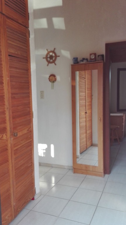 Ein Schrank mit Putzmittel und kleinem Handwerkszeug links  und geradeaus Schuhschrank mit Spiegel